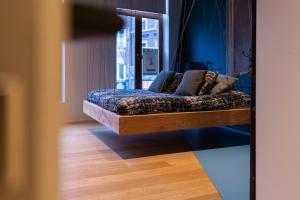 a bed in a room with a wooden floor at The Hide in Ghent