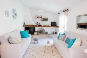 een woonkamer met 2 witte banken en een open haard bij Da Fe' - Casa con terrazza panoramica in Cuglieri