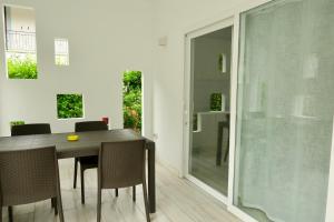 uma sala de jantar com mesa e cadeiras e uma porta de vidro em Da Benedetto em Gaeta