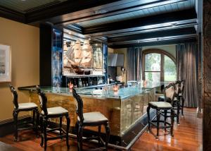 a bar with a glass counter and chairs at Mansion on Forsyth Park in Savannah