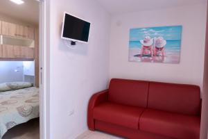 a living room with a red couch and a tv at Da Benedetto in Gaeta