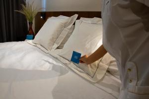 a person is standing next to a bed with pillows at Hotel Marielena in Cuatrociénegas de Carranza