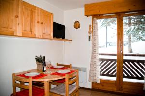 a dining room with a table and a window at Your apartment near the ski lift in Aime-La Plagne