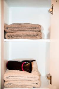 a shelf with towels and a bottle of lipstick at Your apartment near the ski lift in Aime-La Plagne
