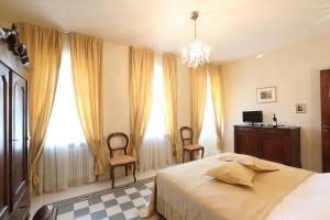 a bedroom with a bed and two chairs and a desk at Locanda Dell' Orso Bevitore in Verduno