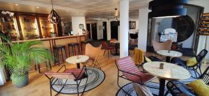 een restaurant met tafels en stoelen en een bar bij Le Relais du Valois Cognac Centre in Cognac