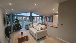 uma sala de estar com uma árvore de Natal e um sofá em The Deneb em Amotherby