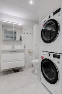 un bagno con lavatrice e lavandino di Tapiola Oak Apartment a Espoo