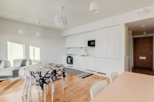 a kitchen and living room with a table and chairs at Tapiola Oak Apartment in Espoo