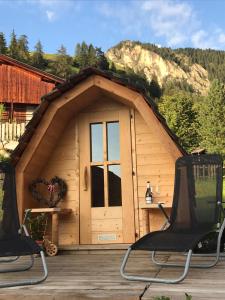 a small cabin with two chairs on a wooden deck at Agriturismo Tolpei in La Valle