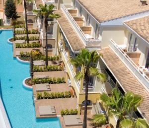 an aerial view of a hotel pool with palm trees at Insotel Cala Mandia Resort in Cala Mendia