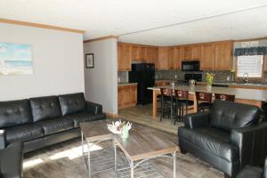 uma sala de estar com mobiliário de couro preto e uma cozinha em Island Club #111 em Put-in-Bay