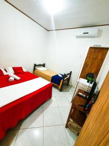 a small room with two beds and a table at Pousada Marraial in Arraial d'Ajuda