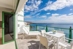 balkon ze stołem i krzesłami oraz oceanem w obiekcie SEA BREEZE Ocean View Apartment w mieście Playa Blanca