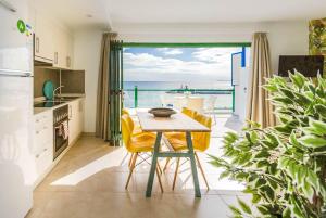 - une cuisine avec une table et une vue sur l'océan dans l'établissement SEA BREEZE Ocean View Apartment, à Playa Blanca