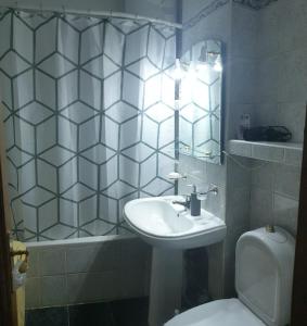 a bathroom with a sink and a toilet and a mirror at Apartament Central Vatra Dornei in Vatra Dornei