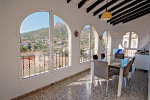 a dining room with large windows and a table and chairs at Tosal Julia - sea view villa with private pool in Calpe in Calpe