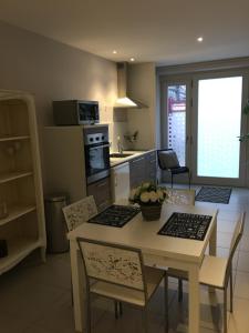 La Suite Alain في نانسي: مطبخ وغرفة طعام مع طاولة وكراسي