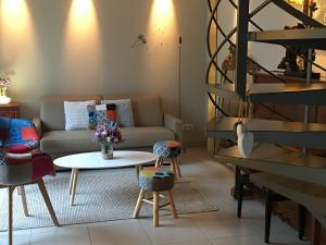 ein Wohnzimmer mit einem Sofa, einem Tisch und Stühlen in der Unterkunft La Suite Alain in Nancy