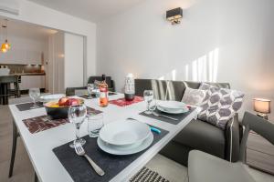 a dining table with plates and wine glasses on it at COZY studio-flat in PACEVILLE in St. Julianʼs