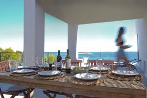 a wooden table with wine bottles and plates of food at 180° Sea View Private House Vis Island archipelago in Podstražje