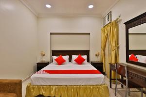 um quarto com uma cama grande e almofadas vermelhas em نسمات الشرق للشقق المخدومه em Al Khobar