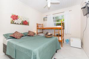 a bedroom with a bed and a table and a window at Kundalini Buzios in Búzios