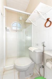 a white bathroom with a toilet and a shower at Kundalini Buzios in Búzios