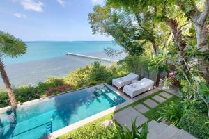 an outdoor swimming pool with a view of the ocean at The Headland Villa 2, Samui in Koh Samui