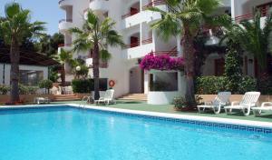 a swimming pool in front of a building at Sagitario Vista Playa I Apartamentos in Cala Blanca