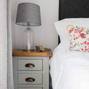 a lamp on a night stand next to a bed at Number Seven in Newquay