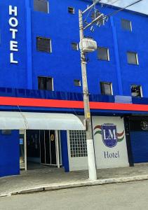 a blue hotel with a light pole in front of it at LM Hotel in Sao Paulo