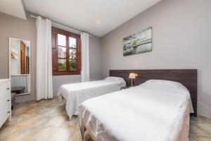 a bedroom with two beds and a window at Casa Manolo in Cala Ratjada +17 photos