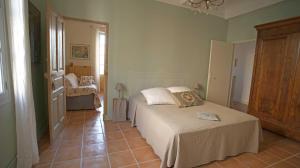 a bedroom with two beds and a tiled floor at Au coin de la Roquette in Arles