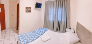 a bedroom with a bed with a blue and white cover at Nacional Park Hotel Lages in Lages