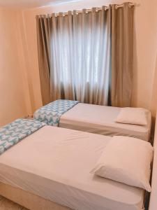 two beds in a room with a window at Nacional Park Hotel Lages in Lages