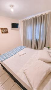 a bed in a room with a window at Nacional Park Hotel Lages in Lages