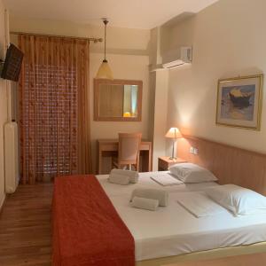 Un pat sau paturi într-o cameră la Saronis Hotel