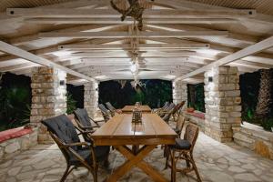 a wooden table and chairs on a patio at ORRAON Lux Aparts K in Preveza