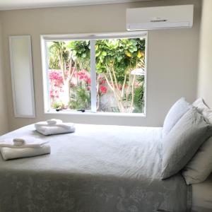 um quarto com uma cama grande com duas toalhas em Cozy Cottage em Whitianga