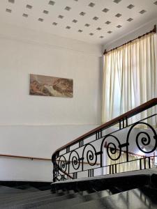 Cette chambre blanche dispose d'un balcon orné d'une peinture murale. dans l'établissement Hotel Capri de Leon Mexico, à León