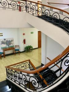 a spiral staircase in a building with a lobby at Hotel Capri de Leon Mexico in León