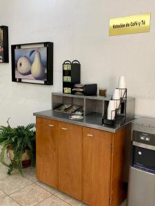 - une cuisine avec un comptoir et une télévision murale dans l'établissement Hotel Capri de Leon Mexico, à León