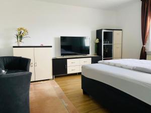 ラーティンゲンにあるApartment 1OGのベッドルーム(ベッド1台、薄型テレビ付)