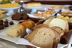 a table filled with bread and pastries and other desserts at Ilha Branca Exclusive Hotel in Búzios