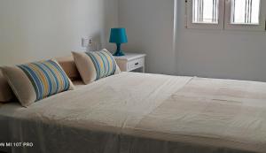 un letto con due cuscini sopra in una camera da letto di Ayamonte Centro ad Ayamonte