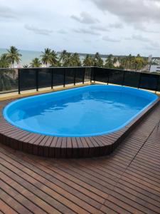 uma grande piscina azul num deque com praia em Flat à beira mar em João Pessoa