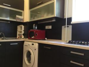 a kitchen with a washing machine and a red microwave at Corso Quiet in Budapest