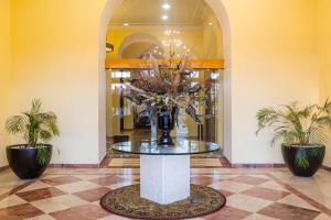 a table with a vase of flowers in a lobby at Gran Hotel de Querétaro in Querétaro