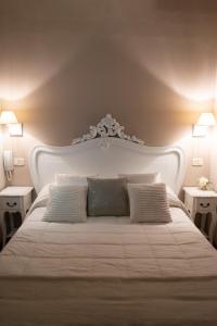 a white bed with two pillows and two tables at B&B Alexander in Pollutri